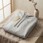 Minimalist light gray hooded sweatshirt with Breathe deeply embroidery, Innerway Studio mockup.